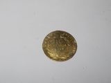 a close up of a gold coin on a white surface