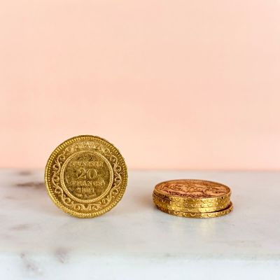 two gold coins sitting on top of a marble counter top