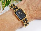 a woman wearing a gold and black watch on her wrist