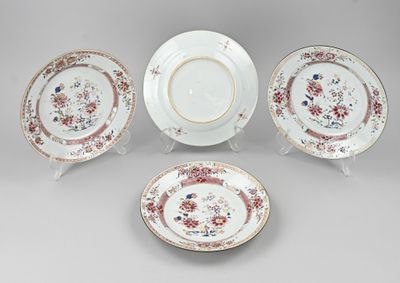 trois assiettes et un bol ornés de motifs floraux, posés sur une table