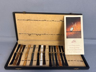 a box with a set of pens and a card in it