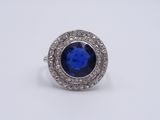 a close up of a blue sapphire and diamond ring on a white background