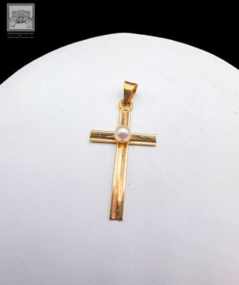 pendentif en forme de croix en or avec une perle au centre