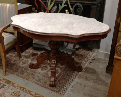 une table au plateau en marbre au milieu du salon