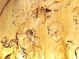 a gold plate with a picture of a group of angels on it