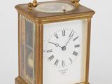 une petite horloge en laiton ornée de chiffres romains