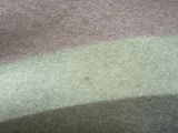 a close up picture of a blanket with a stain of paint on it