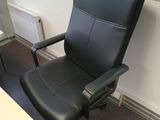 a black office chair sitting in front of a computer desk