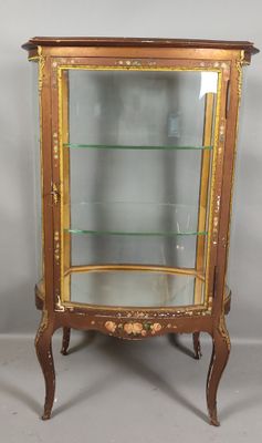 an antique display cabinet with glass shelves and gold trimmings