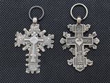 two silver crosses are shown on a black background
