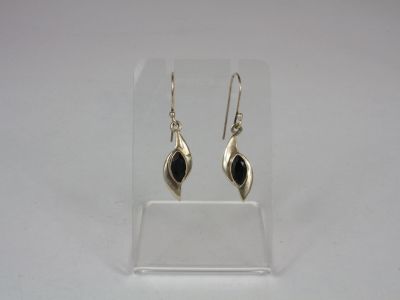 a pair of silver earrings with black stones on them
