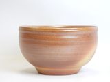 a brown bowl that is sitting on a white surface