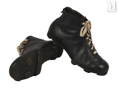 une paire de bottes en cuir noir à lacets sur fond blanc