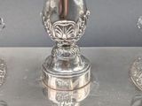 three silver vases on a silver tray on a table
