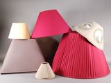 trois lampes de teintes différentes posées sur une surface blanche, avec un abat-jour rose