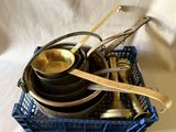 Plusieurs casseroles et poêles sont empilées les unes sur les autres dans un panier