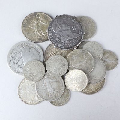 a pile of silver and silver coins on a white surface