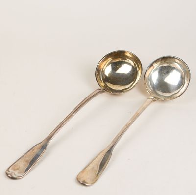 deux cuillères en argent posées l'une à côté de l'autre sur une table