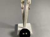 pair of black and white earrings with a black button on a white stand