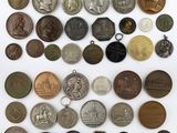 a large collection of old coins and medals on a white surface