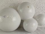 three white eggs sitting on a table next to a white wall