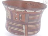a brown bowl with designs on it on a white surface