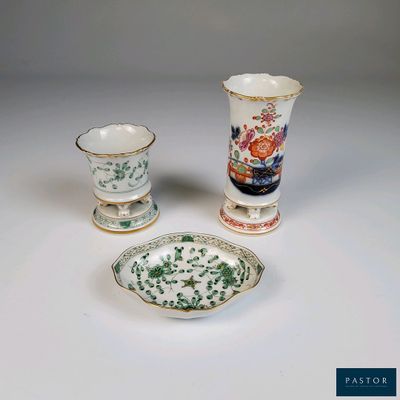 trois types de vases différents et une assiette posés sur une table