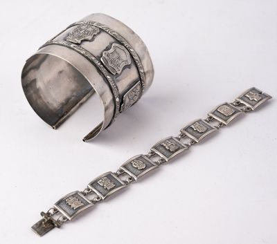 two silver bracelets and a silver bracelet on a white surface