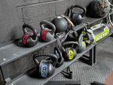 many kettle weights on a rack in a gym