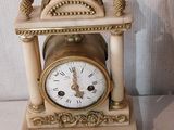 une horloge posée sur une table à côté d'une pièce de monnaie