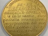 a close up of a gold coin on a white surface