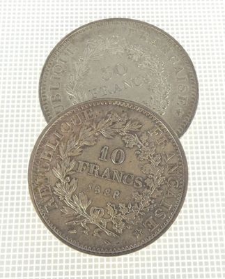 two silver coins with a wreath on top of them on a white surface