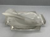 a glass bird that is sitting on top of a glass plate