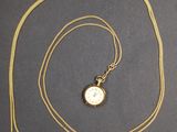 une photo d'un collier plaqué or orné d'une horloge