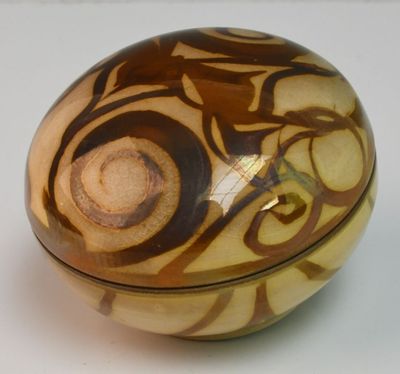 un bol marron et blanc posé sur une surface blanche