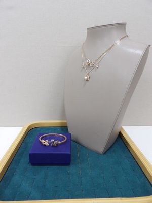 un collier, une bague et un écrin à bague exposés dans une vitrine