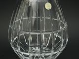 un vase en verre transparent orné d'une étiquette dorée