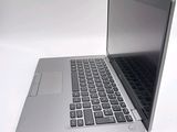 a silver laptop with a black keyboard on a white surface