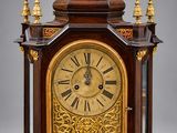 une vieille horloge en bois surmontée d'un aigle royal
