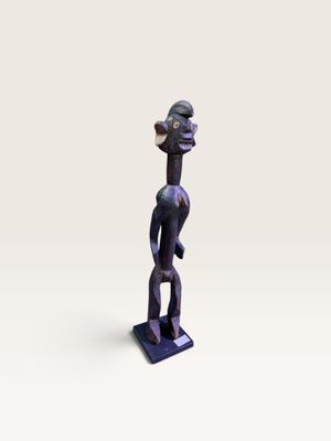 une petite statue d'un homme avec un chapeau sur la tête