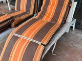 deux chaises longues qui se trouvent dehors, sur la terrasse