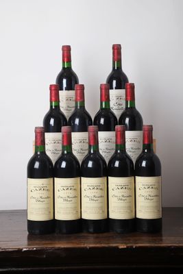 six bouteilles de vin rouge sont posées sur une table devant un mur blanc