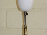 a lamp that is sitting on a table in front of a brick wall