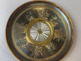 a gold plate with a clock on it on a table