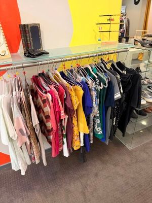 beaucoup de vêtements suspendus à une étagère dans un magasin
