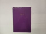 une photo d'un livre violet posé sur un mur blanc