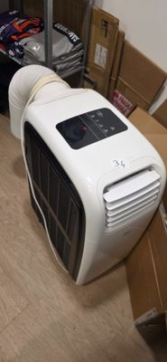 un climatiseur blanc posé par terre à côté d'une pile de cartons
