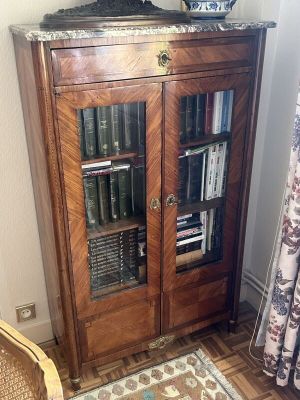 une armoire sur laquelle sont posés des livres, dans un coin de la pièce