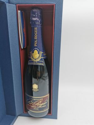 La bouteille de champagne se trouve dans un coffret cadeau bleu, avec un stylo à l'intérieur.