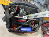 un sac rempli d'outils posé par terre